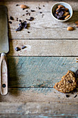 Angebissenes Haferplätzchen mit Mandeln und Chocolate Chips auf rustikalem Holzuntergrund