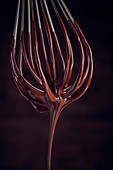 Liquid chocolate dripping from a whisk