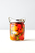 A glass jar of preserved tomatoes