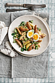 Potato salad with broad beans, a soft-boiled egg and ham crumble