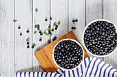 Fresh blueberries in bowls on a wooden background