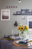 Herbstlich gedeckter Tisch in Grau mit Sonnenblumenstrauß