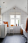 Badezimmer mit weißen Wandfliesen im Dachgeschoss