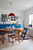 Wooden table and chairs in front of blue sideboard in dining room
