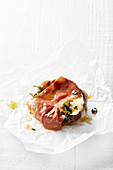 A portobello mushroom wrapped in prosciutto with cheese