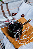 Jam in a glass jar on a fabric pillow
