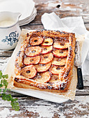 Puff pastry cake with apples, cinnamon, powdered sugar and cream