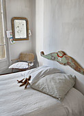 Betthaupt mit abgenutzter Farbe im schlichten Schlafzimmer