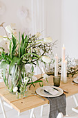 Gedeckter Hochzeitstisch mit Tulpenstrauß, trockenen Zweigen und Cylinderkerzen