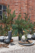 Table set for Christmas with fir branches and black candles