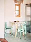 Kleiner Frühstückstisch und mintfarbene Stühle