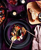 Meeresfrüchte-Paella serviert mit Brot und Wein (Aufsicht)