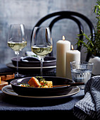 Knuspriges Polenta-Fondue auf gedecktem Tisch mit Wein und Kerzen