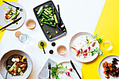 Gedeckter Tisch mit Buttermilch- und Kartoffelsuppe, Gurken mit Basilikumöl und Quinoa mit frittiertem Rotkohl