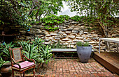 Antique chair on terrace in front of natural stone wall