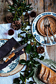 Weihnachtlich gedeckter Tisch mit Rotwein und Brot (Aufsicht)