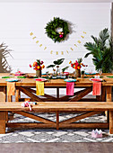 Colorfully laid wooden table with bench against wall with Christmas decoration