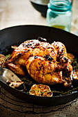 Chicken with an orange glaze, spices and garlic in a pan