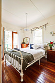 Double bed in the bedroom with balcony and rustic wooden floor