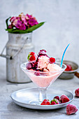 Homemade berry ice cream served with frozen berries