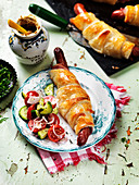 Sausages in puff pastry with tomato and cucumber salad