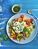 Colourful tomato salad with mozarella and gorgonzola and basil pesto