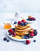 Pancakes with colourful berries and honey