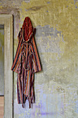 Gestreifter Bademantel an Vintage Wand hängend