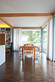 Dining table in open-plan interior with glass walls