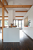weiße Designerküche mit Kücheninsel in offenem Wohnraum