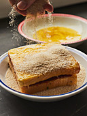 A sandwich being breaded