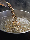 Lentils being poured into boiling water