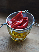 Pickled grilled peppers being drained