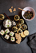 Two types of cracker crostini with tapenade and cream cheese