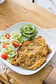 Breaded schnitzel with salad and herb spaghetti