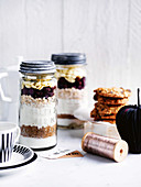 Ingredients for baking cookies: oatmeal, cranberries and white chocolate chips in glass jars