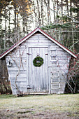 Wooden garden shed decorated with Christmas wreath