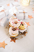 Donuts with pink icing decorated with pink sprinkles and gold leaf