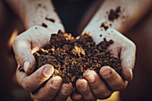 A person holding a handful of soil