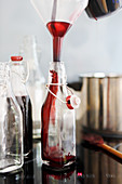Elderberry juice being poured into glass bottles