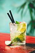 Mojito cocktail with fresh lime and mint on a wooden table
