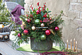 Weihnachtsgesteck mit Koniferenzweigen und Christbaumkugeln