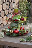 Homemade cake stand with Christmas baubles, cones and branches
