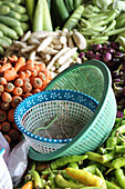 A vegetable stand with plastic bowls in the foreground