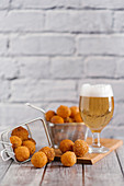 Fried cheese balls and a glass of light beer