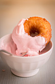 Ein Donut mit rosafarbenem Frosting