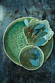 Eucalyptus sprig lying across green ceramic dishes