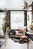 Sessel und Weihnachtsbaum vor schwarz gemusterter Tapete