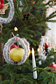 Weihnachtsbaum mit Apfel und Kerze geschmückt
