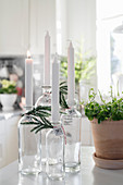 DIY candlesticks made from glass bottles decorated with fir sprigs